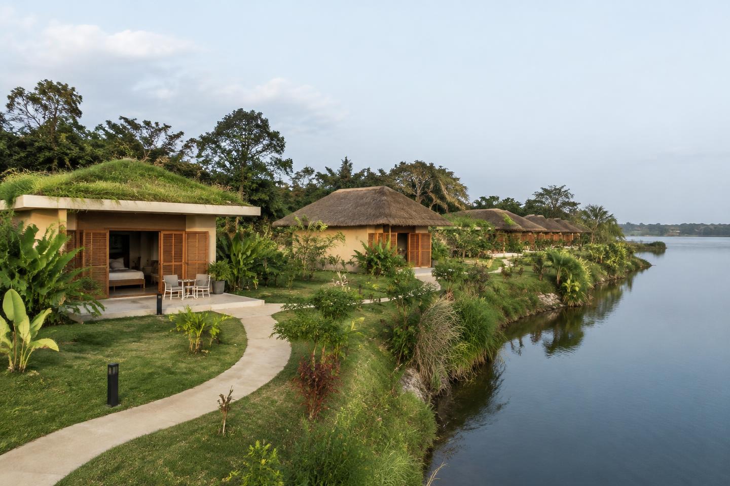 Bungalows de l'éco-hôtel au bord du lac : moitié à enduit clair, moitié en briques de terre compressée stabilisée avec toit de paille