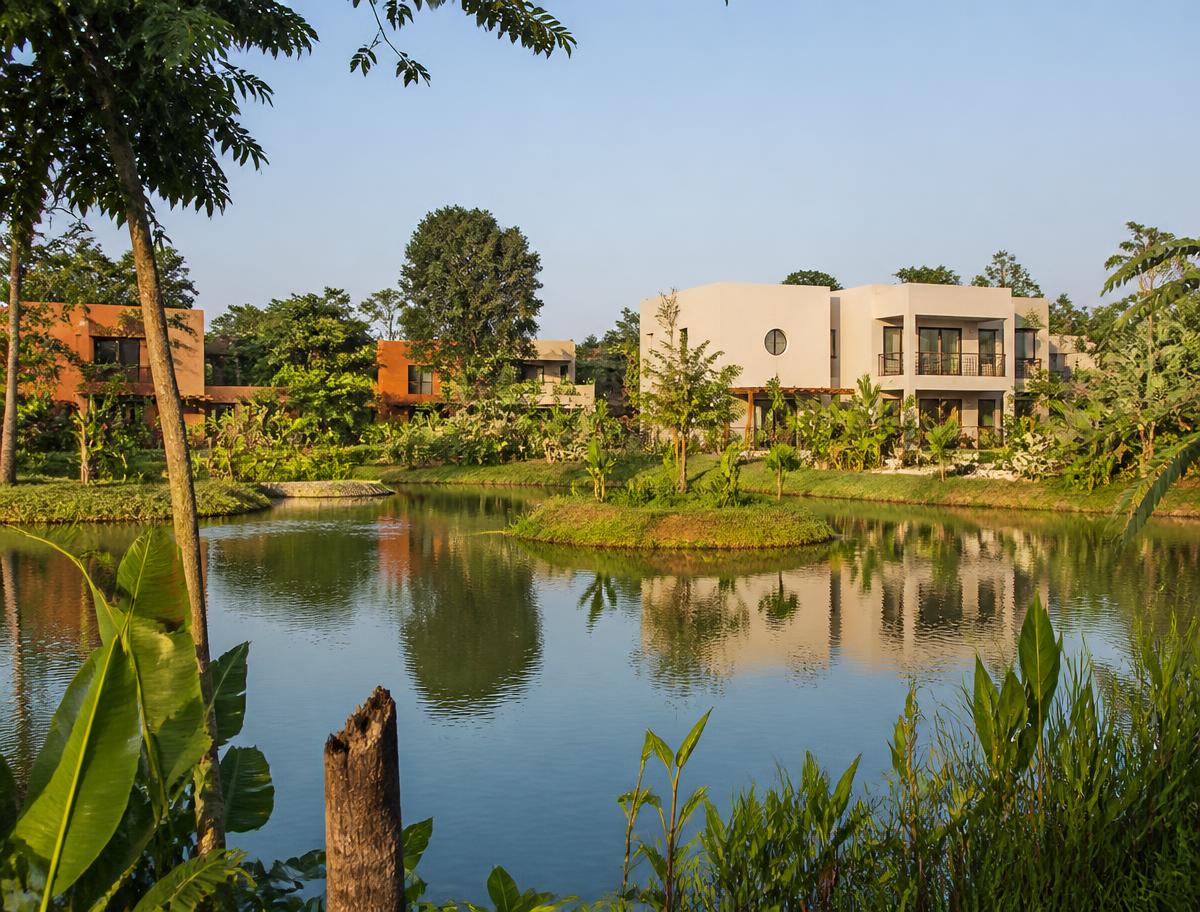 Lac au cœur du village, bordé de maisons et de jardins tropicaux